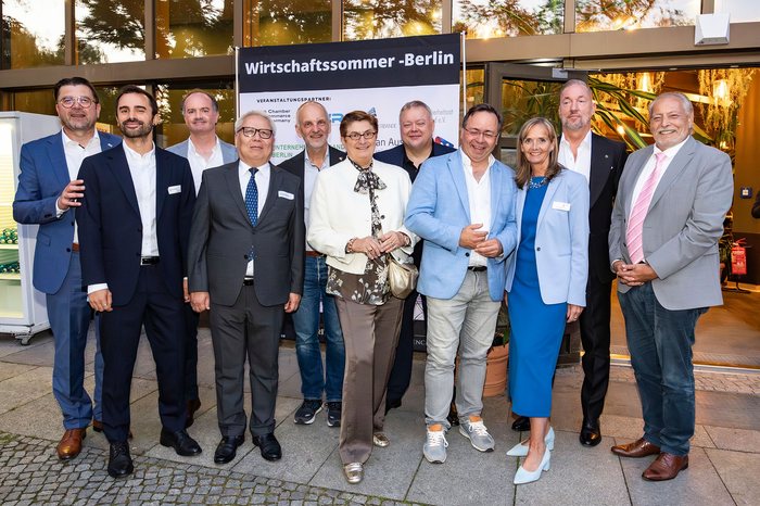 Gruppenbild mit Vertreterinnen und Vertretern der beteiligten Verbände vor einer Veranstaltungswand.